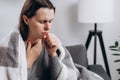 Ill young brunette female covered blanket have fever, flu or sore throat and sneezing until chest pain while rest at home. Health Royalty Free Stock Photo