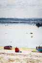 A man rests with his dog near of Small boats for artisanal fishing Royalty Free Stock Photo