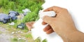 Illegal dumping with bottles, boxes and plastic bags abandoned in nature - concept image with hand that is erasing Royalty Free Stock Photo