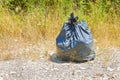 Illegal dumping - garbage plastic bag left in the nature Royalty Free Stock Photo