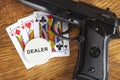 Illegal gambling concept with a handgun and poker hand and dealer chip Royalty Free Stock Photo