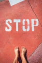 An illegal immigrant stands barefoot at a stop sign on the ground Royalty Free Stock Photo