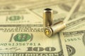 Illegal selling, criminal money concept, US dollars and bullet for a gun, 9mm pistol cartridges on the background