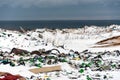 Illegal trash dump in the Arctic snow polluting the pristine environment next to the sea