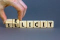 Illicit or elicit symbol. Businessman turns wooden cubes and changes the concept word Illicit to Elicit. Beautiful grey table grey Royalty Free Stock Photo