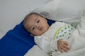 Illness asian baby boy lying down on sickbed and looking at camera Royalty Free Stock Photo