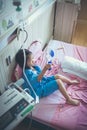Illness asian child admitted with saline iv drip on hand.