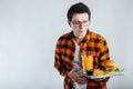 Illness sad young man in shirt put hand on pain abdomen, stomach-ache, standing and holding burger isolated on white background. P Royalty Free Stock Photo