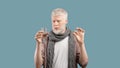 Illness treatment. Sick albino man holding pill and glass of water, taking medicine over turquoise background