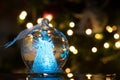 Illuminated angel figure in glass bulb, soft boke christmas ligh Royalty Free Stock Photo