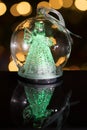 Illuminated angel figure in glass bulb, soft boke christmas ligh Royalty Free Stock Photo