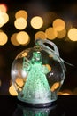 Illuminated angel figure in glass bulb, soft boke christmas ligh Royalty Free Stock Photo