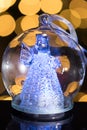 Illuminated angel figure in glass bulb, soft boke christmas ligh Royalty Free Stock Photo