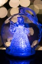 Illuminated angel figure in glass bulb, soft boke christmas ligh Royalty Free Stock Photo