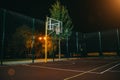 Illuminated basketball playground with red pavement, modern new basketball net Royalty Free Stock Photo
