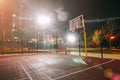 Illuminated basketball playground with red pavement, modern new basketball net Royalty Free Stock Photo