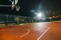 Illuminated basketball playground with red pavement, modern new basketball net Royalty Free Stock Photo