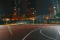 Illuminated basketball playground with red pavement, modern new basketball net Royalty Free Stock Photo