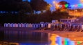 Illuminated beachfront with colour huts and reflection in the sea