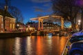 Illuminated bridge in the old town of Amsterdam in the evening