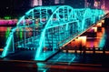 Illuminated bridge on top of a river in a cityscape at night
