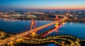 Illuminated Cable- Stayed Bridge Over River at Dusk with City Skyline cable-stayed bridge Royalty Free Stock Photo