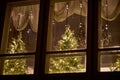 Illuminated christmas tree behind window with warm holiday lights Royalty Free Stock Photo