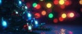 Illuminated Christmas tree in a dark room, adorned with ball toys, twinkling lights and decorations Royalty Free Stock Photo