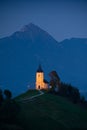 Illuminated The Church of St. Primoz and Felicijan in the village of Jamnik in the Slovenian Alps at night. Vertical view Royalty Free Stock Photo