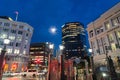 Illuminated city commercial skyline from waterfront with tall building with lights and street lights