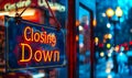 Illuminated Closing Down sign hanging in a storefront window at dusk, signaling the end of business operations, with city lights Royalty Free Stock Photo