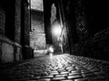 Illuminated cobbled street in old city by night