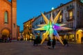 Illuminated colorful Christmas star on town square in Italy.