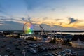 Illuminated colorful Ferris wheel at an amusement park in Ocean City Maryland against the sunset sky
