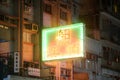 Illuminated colorful neon sign hanging on a building in Kowloon City at night. Vertical shot