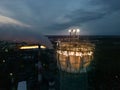 Illuminated construction site at dusk.Dangerous work at the nighttime.Workers build a tall chimney for a plant.Construction Royalty Free Stock Photo