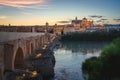 Illuminated Cordoba Skyline at sunset with Cathedral, Roman Bridge and Guadalquivir River - Cordoba, Andalusia, Spain Royalty Free Stock Photo