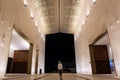 Illuminated courtyard of Mosque of Light in Dubai with Muslim woman standing in the middle.