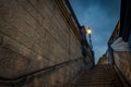 Illuminated dark ghostly looking stairs in London, England at night surrounded by brick walls and one lamppost Royalty Free Stock Photo