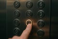 An illuminated elevator button is pressed, surrounded by Braille-labeled buttons, supporting accessibility for visually impaired Royalty Free Stock Photo