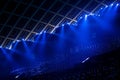 Illuminated empty blue stadium with a large stage