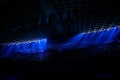 Illuminated empty blue stadium with a large stage