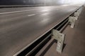 illuminated empty foggy night road with rigid guardrails
