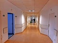 Illuminated and empty hospital corridor with many rooms Royalty Free Stock Photo