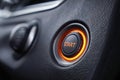 Illuminated engine start button in modern vehicle dashboard surrounded by textured black leather interior promoting easy push-to- Royalty Free Stock Photo