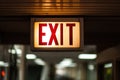 Bright exit sign guiding individuals towards safety in a well-lit corridor during evening hours Royalty Free Stock Photo
