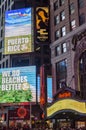 Illuminated facades of Broadway stores and theaters