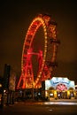 Illuminated Ferris wheel stands majestically at night with bright red lights: Vienna, Austria