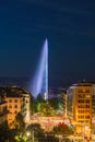 Illuminated Geneva Water Fountain Jet d`Eau - the city`s most famous landmark - summer evening view with blue sky, Geneva, Royalty Free Stock Photo