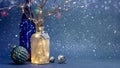 Illuminated glass bottles decorated with tree branches and christmas lights and festive decorations on blue background Royalty Free Stock Photo
